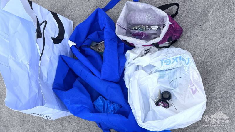 志工在看似乾淨的沙灘上撿到不少細小的塑膠垃圾