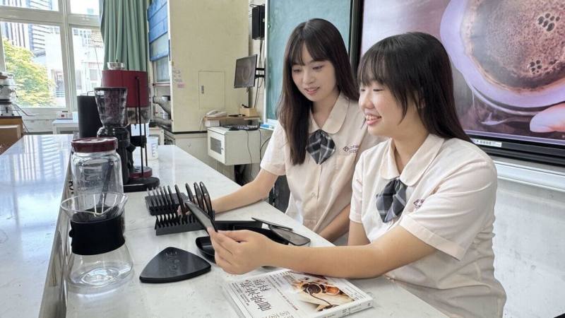 高雄市三民家商學生侯芊妘（左）、張驊軒（右）等人以所學協助屏東縣瑪家鄉咖啡產業，結合AI技術與RPG遊戲設計，開發以偏鄉咖啡為主題的遊戲「勇者與魔豆的試煉」，獲高中生AI扎根系列活動「特別表現獎」。（三民家商提供）