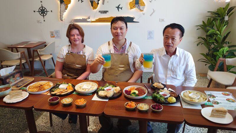 嘉義縣長翁章梁（右）聽聞「說說咖啡」有著美味的異國料理，11日到店品嚐烏克蘭的醃肥豬肉、基輔肉丸、手工水餃及呈現烏克蘭國旗藍黃顏色的招牌飲品「榮耀歸烏克蘭」，對老闆胡貽琮（左2）、老闆娘佐里娜（Zoriana）（左1）的手藝贊不絕口。