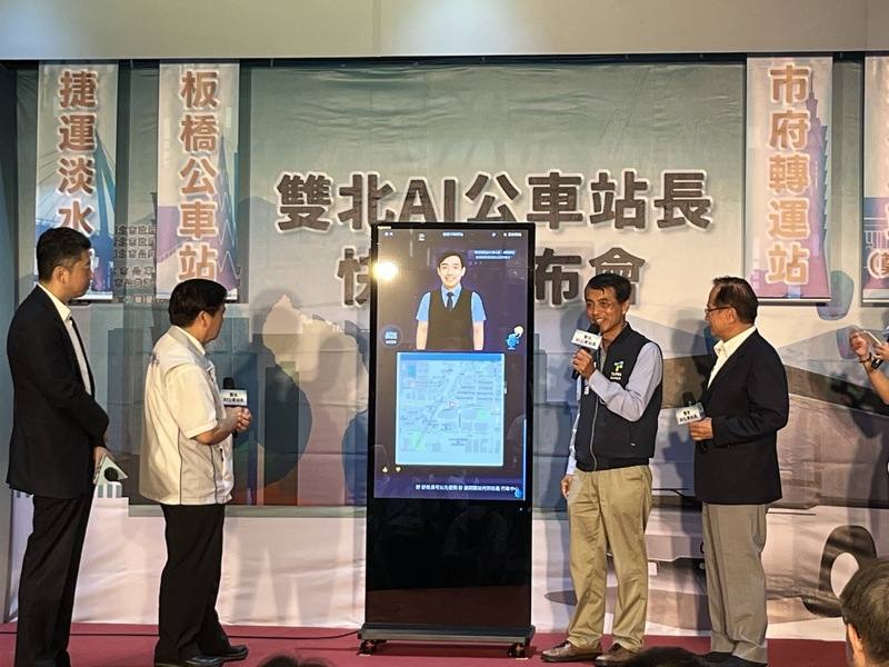 The Taipei City Government Department of Transportation Commissioner Hsieh Ming-hong (second right) and New Taipei City Transportation Department Commissioner Chung Ming-shih (second left) introduce the "Taipei-New Taipei AI Bus Stationmaster Ah-Ming" at 