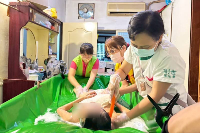 創世基金會板橋分院14日表示，長照壓力沉重，創世盼建立守護網照顧弱勢，並提供到宅服務。圖為基金會到宅服務，為婦人提供原床泡澡服務。（創世基金會板橋分院提供）