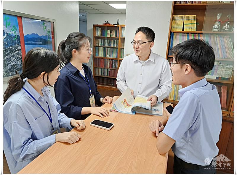 莊博智向團員介紹中心提供僑校免費教材並回答問題