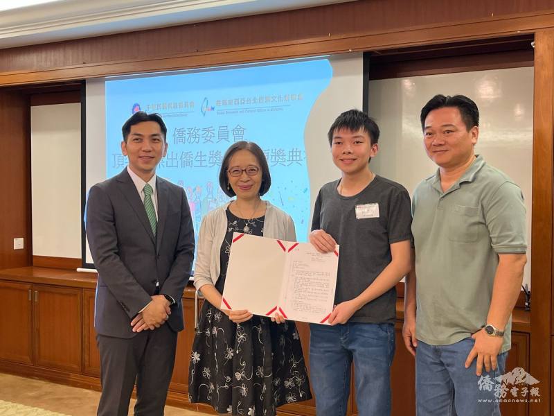 葉非比頒發頂尖及傑出僑生獎學金證書給獲獎同學林應恩，僑務組組長廖建勛(左1)、家長暨砂拉越留臺同學會民都魯分會主席林履財(右1)