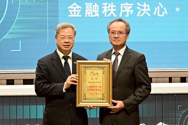 中華民國銀行商業同業公會全國聯合會13日舉辦「114年金融科技打詐高峰會」，會中由行政院秘書長龔明鑫（左）表揚阻詐有功的中華郵政公司，由總經理江瑞堂（右）代表受獎。（中華郵政提供）