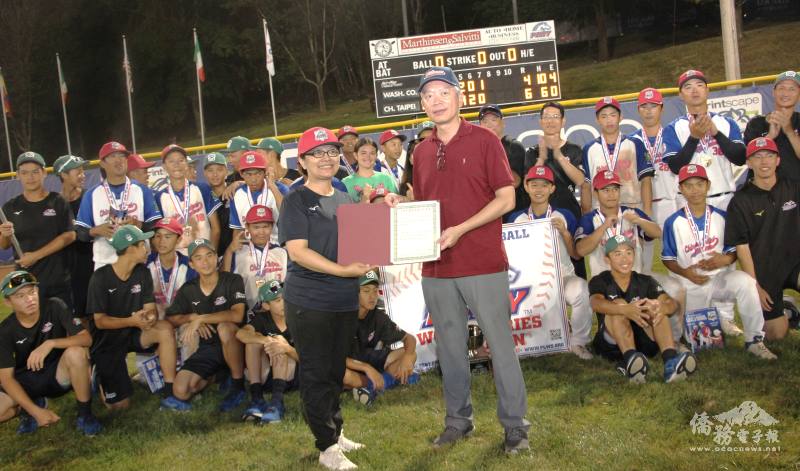 駐紐約辦事處大使李志強（右）頒駐美大使俞大㵢賀電，由中山國中校長王蒲寧（左）代表接受