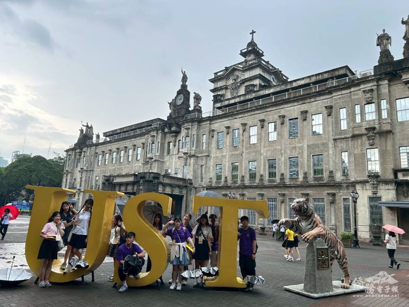 搭僑青年於UST主校區地標招牌前合影留念