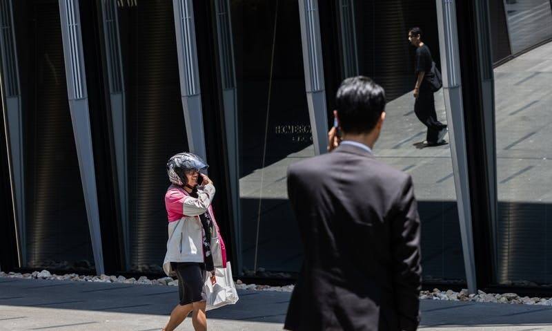 圖為台北市信義區街頭的外送員與上班族