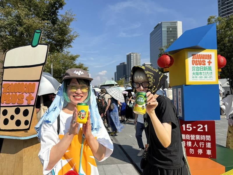 文總主辦的「TAIWAN PLUS 2025 台日新風」邁入第二週，台灣經典美食齊聚大阪中之島公園，吸引大批民眾在酷熱天氣下排隊購買。現場遊客綁著頭巾喝台灣啤酒、吃烤香腸，氣氛宛如台灣夜市，洋溢濃濃台灣味