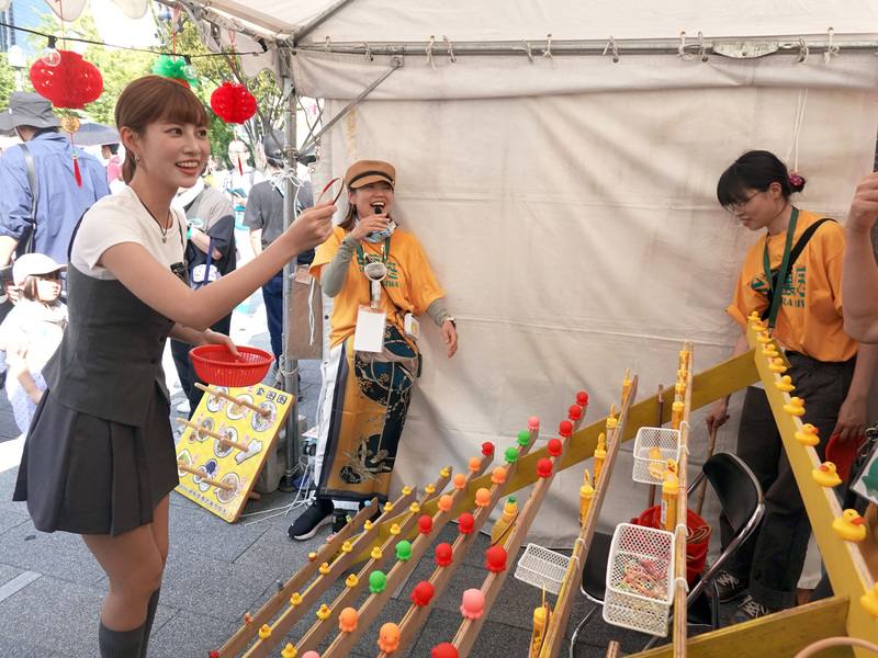 Taiwan-based Japanese entertainer Abe Maria (front left) appears at a stand on Sunday. CNA photo Aug. 17, 2025