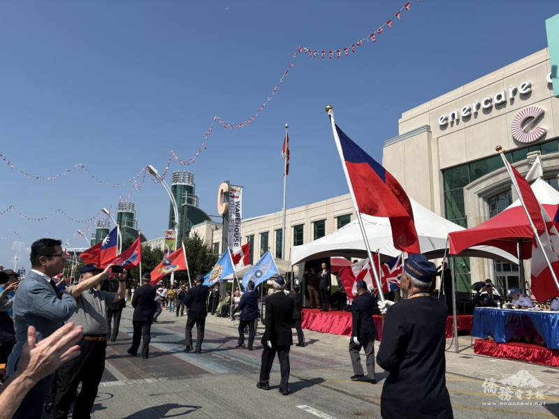 多倫多文教中心主任藍柏青在校閱現場向遊行隊伍致意