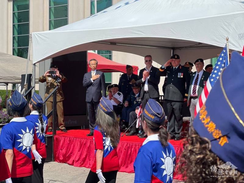 駐多倫多辦事處處長梁毅鵬在遊行觀禮臺上向行經的榮光隊伍答禮致敬