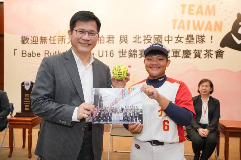 隊長柯子慧（右）致贈全球隊親簽之壘球並合照。