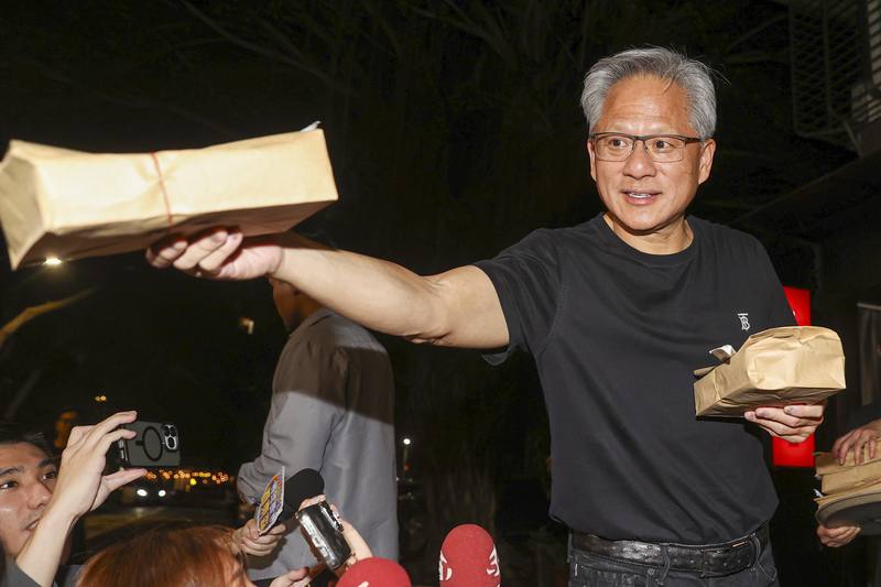 輝達（NVIDIA）執行長黃仁勳（右）22日快閃訪台、行程滿檔。黃仁勳晚間與台積電董事長魏哲家共進晚餐，席間從餐廳拿餐盒送給現場守候民眾，展現親和力。