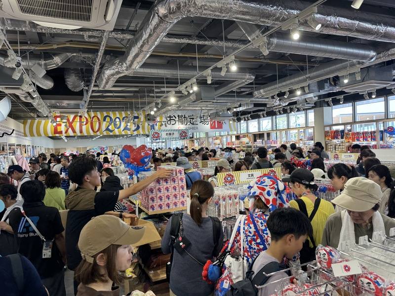 大阪世博自4月13日開幕至本月20日，進場遊客突破1500萬人。暑假遊客大增，平均一天13萬4000人。圖為8月19日會場西門附近商店遊客多景象。中