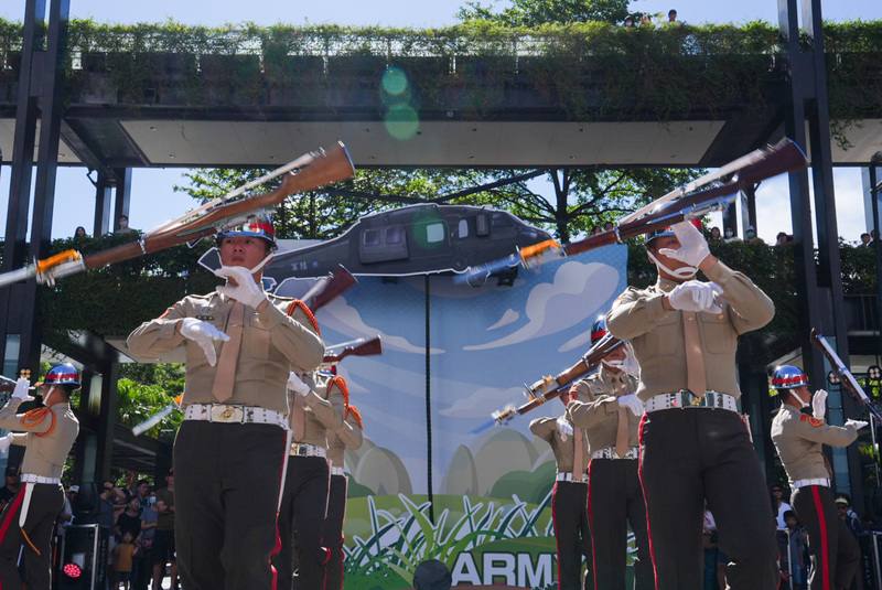 國防部24日於北市信義區舉辦九三軍人節嘉年華，圖為陸戰隊儀隊演出高難度的「靜默槍法」