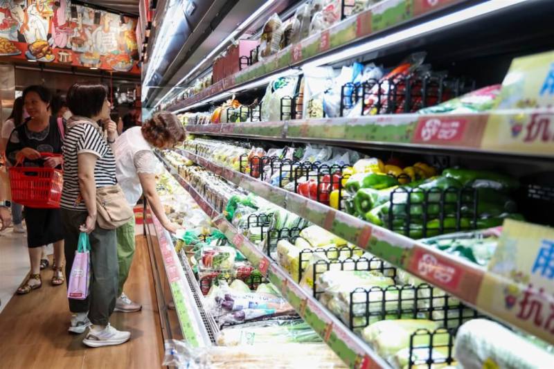 圖為民眾在台北市南港區超市挑選蔬菜