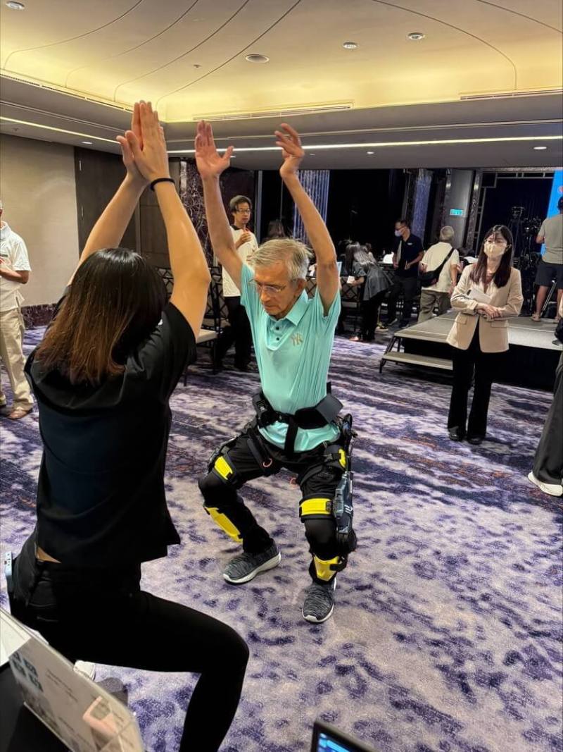 代工廠緯創旗下緯創醫學科技28日在2025樂齡友善調查暨論壇，發表新一代智慧運動下肢外骨骼裝置iKneego，圖為物理治療師帶領與會民眾體驗iKneego進行運動（緯創提供）