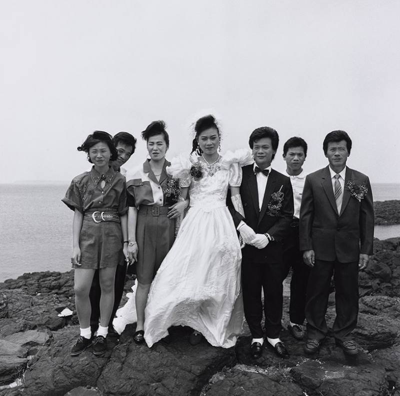 《澎湖印記》07︰〈風櫃〉1991年，馬公風櫃。本作品是攝影家謝三泰外甥結婚當日所拍攝。男方就住在澎湖風櫃洞前，當日迎娶拜堂後，謝三泰為跳脫傳統在門庭前合影的喜事照片，決定請男方家人到風櫃洞旁的玄武岩石岸拍攝一張全家合影