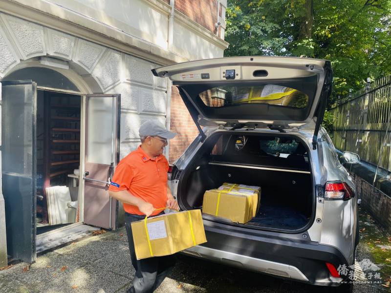 鍾啟元及鄭月鳳逐箱將厚重教科書搬放置後車廂