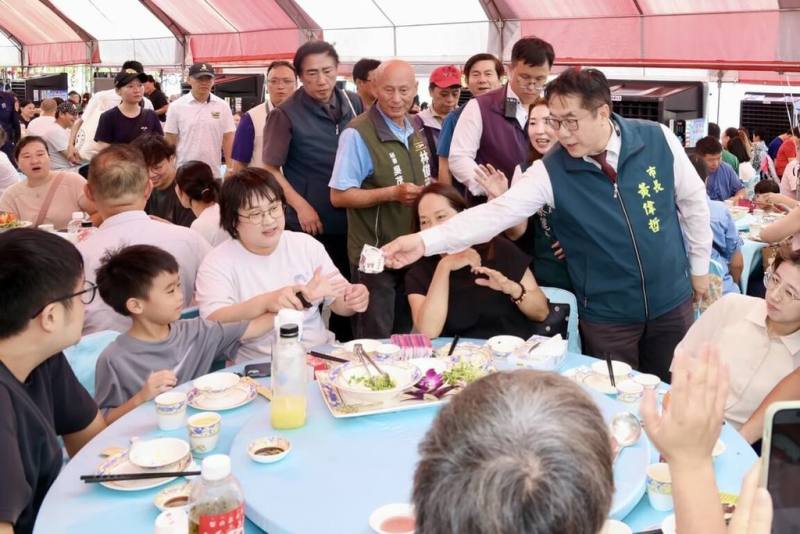 「2025台南總舖師四季辦桌夏季場」30日敲鑼開桌，眾多饕客群集安南區四草大眾廟大快朵頤，台南市長黃偉哲（右）也到場同歡。（台南市政府提供）