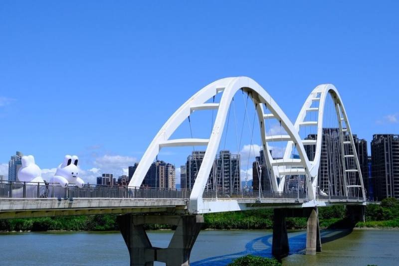 新北市政府攜手藝術家Alan Hong創作IP「雲朵阿Q」，並以新月橋為靈感推出巨型氣偶藝術裝置「兔兔Q」，9月起將進駐新月橋及新月廣場。（新北市政府提供）