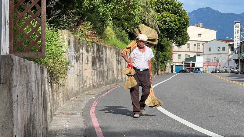 Chang Shui strolls through the alleys of Taitung County, carrying several brooms for sell in Taitung County on Wednesday. CNA photo Sept. 3, 2025
