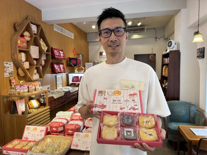 百年糕餅品牌李亭香總經理李佳陽手持以貓為主題的產品，透露近兩年銷售翻倍，部分因貓店長攝影比賽的後續曝光效應。