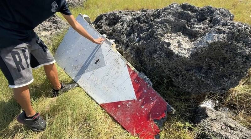 A beach cleaner picks up the metal object in Taitung on Frida that was believed to be the debris of a crashed Brave Eagle advanced jet trainer. Photo courtesy of a private contributor Sept. 6, 2025