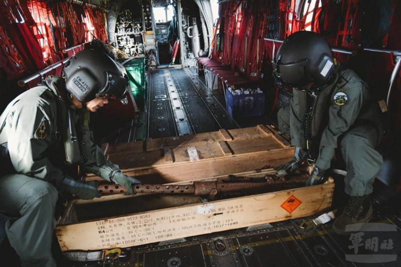Two military personnel carry debris from the Sancha Mountain plane crash site aboard a CH-47 helicopter in this undated photo. Photo courtesy of the Military News Agency
