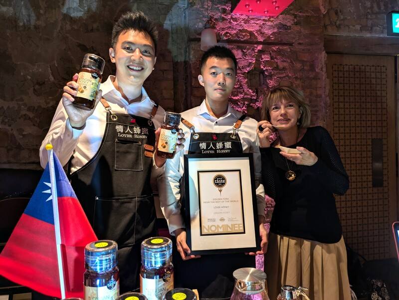 雲林「情人蜂蜜」公司以龍眼蜂蜜獲提名角逐英國美食大賞Great Taste Awards最大獎之一「金叉獎」，頒獎典禮9日晚間於倫敦舉行。評審戴維森（右1）形容，入圍的龍眼蜜口感迷人如絲綢。「情人蜂蜜」業務代表黃鼎鈞（左1）特別赴英國推廣產品、領取入圍證書