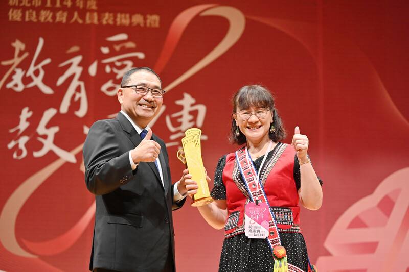 新北市政府11日表揚114年度優良教育人員，由市長侯友宜（左）頒獎給40年資深優良教師，集美國小校長高淑真（右）獲表揚，她也是全國唯一的邵族校長。（新北市新聞局提供）