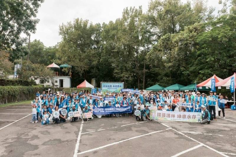 林業及自然保育署台中分署13日與矽品精密工業公司合作，在東勢林場遊樂區內，號召大小志工共同移除小花蔓澤蘭，獲得的收購金全數捐贈偏鄉小學作為課輔基金（矽品公司提供）