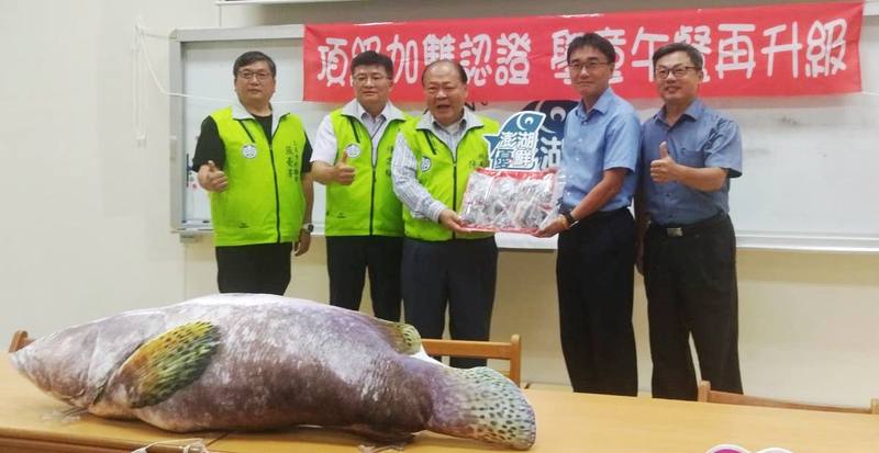 澎湖縣長陳光復（左3）15日到澎湖馬公市文澳國民小學致贈「澎湖優鮮」龍膽石斑魚排1162公斤，由校長洪宏賢（右2）代表接受，將分送全縣每所國中小當營養午餐食材。