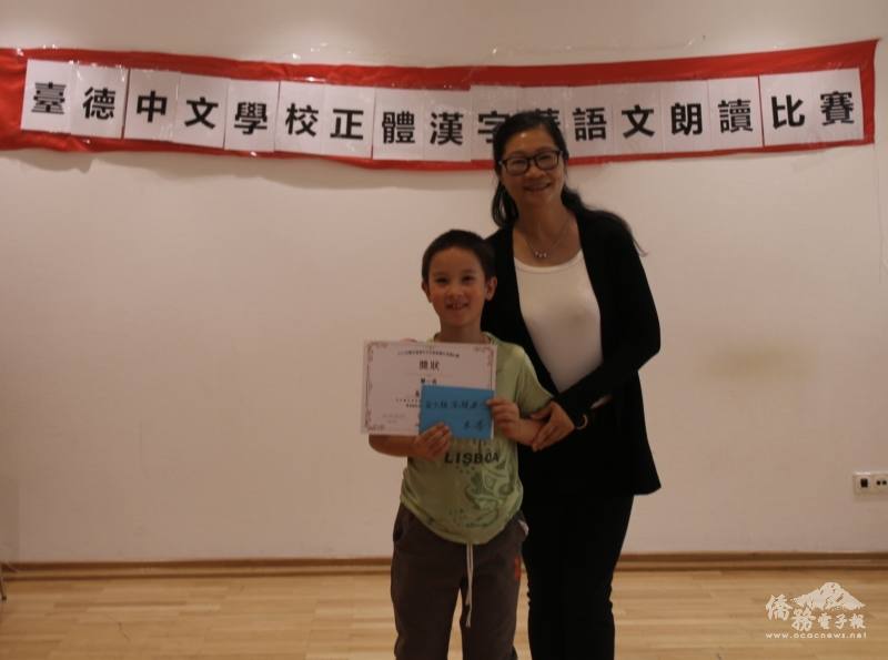 駐法蘭克福辦事處處長羅美舜夫人程宜宜頒獎給兒童少年兒童/少年組 （高級）第一名高宇均同學