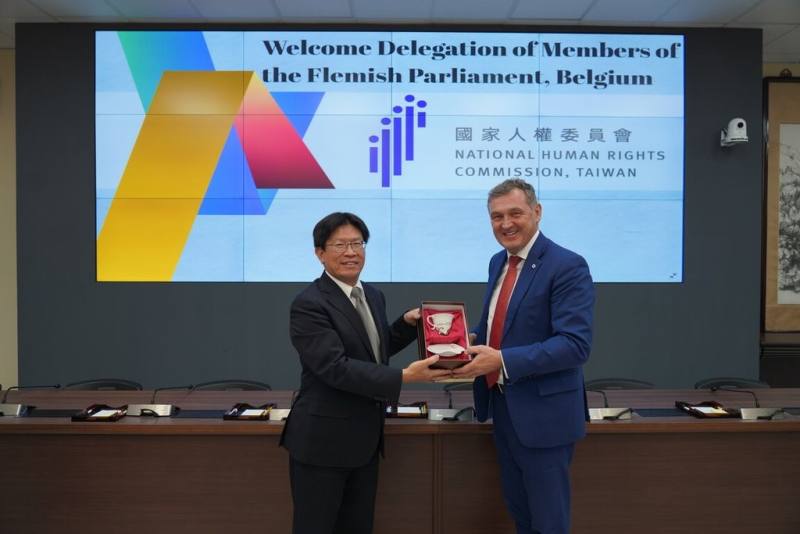 比利時佛拉蒙大區議員訪團15日上午拜訪國家人權委員會，人權會委員高涌誠（左）致贈訪團團長范魯維（右）「浪進」瓷杯，象徵人權推動如同波浪，一波接著一波，乘風破浪引領台灣與比利時共同向前。（人權會提供）