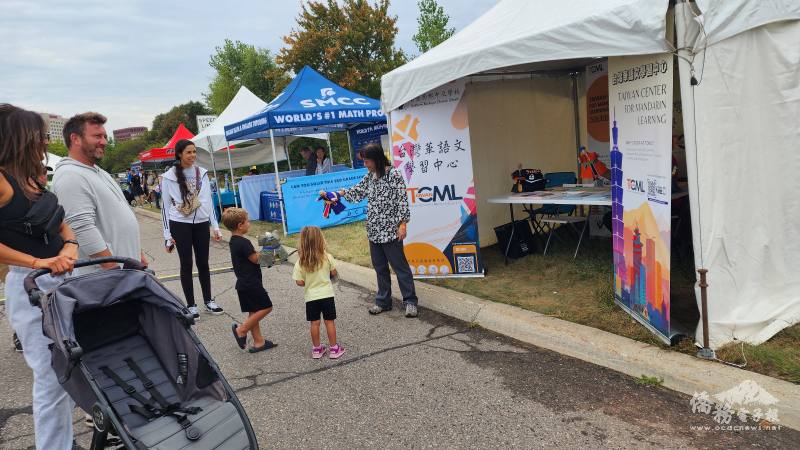 僑務顧問邱美智向小朋友展示布袋戲