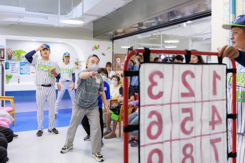 台北市體育局16日攜手台北興富發棒球隊前往一粒麥子社福基金會的莒光社區長照機構，陪伴長者體驗棒球遊戲。（台北市體育局提供）