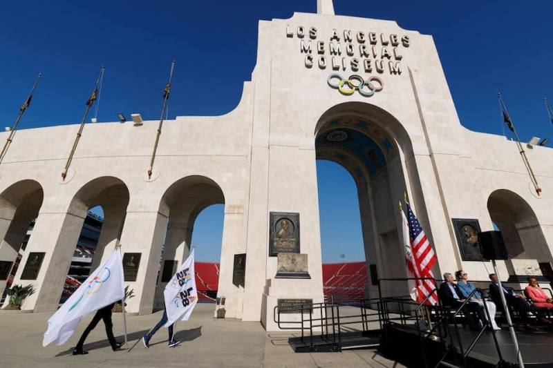 洛杉磯紀念體育場外工作人員舉著奧運旗幟。（路透社）