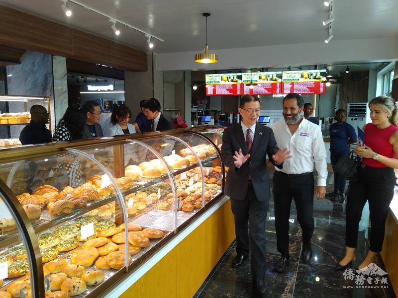 劉翼平（前排右3）陪同訪客參觀，並鼓勵多方選購道地臺式麵包、糕點、珍珠奶茶等飲品。