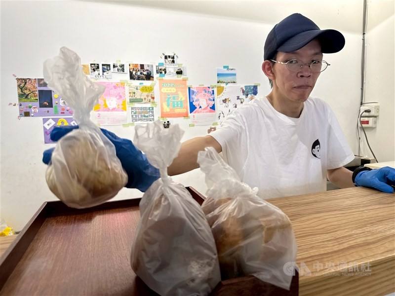 Chang Yun-hsiang heats up bread during his weekly stint at Wanderers’ Lodge, a soup kitchen in Taipei's Wanhua District, which distributes food to people in need. CNA photo Sept. 20, 2025