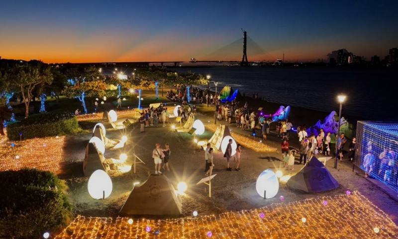 「2025八里城市沙雕展」熱潮持續，新北市政府20日表示，展期將加碼延長至11月2日，並再舉辦6場「沙雕師工作坊」。圖為夜間的沙雕展展區。（新北市高灘地管理處提供）