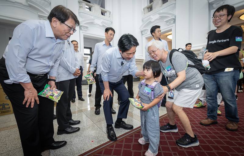 總統在潘孟安秘書長陪同下，先行來到總統府敞廳發送限量版「總統府紀念版乖乖」，歡迎來府參觀民眾，與大家親切互動