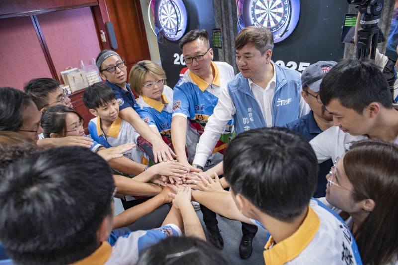 台灣競技飛鏢代表隊22日起參加WDF世界盃飛鏢錦標賽，出發前往韓國前，中華民國競技飛鏢總會會長郭金耀（中右藍背心者）勉勵代表隊選手。（中華民國競技飛鏢總會提供）