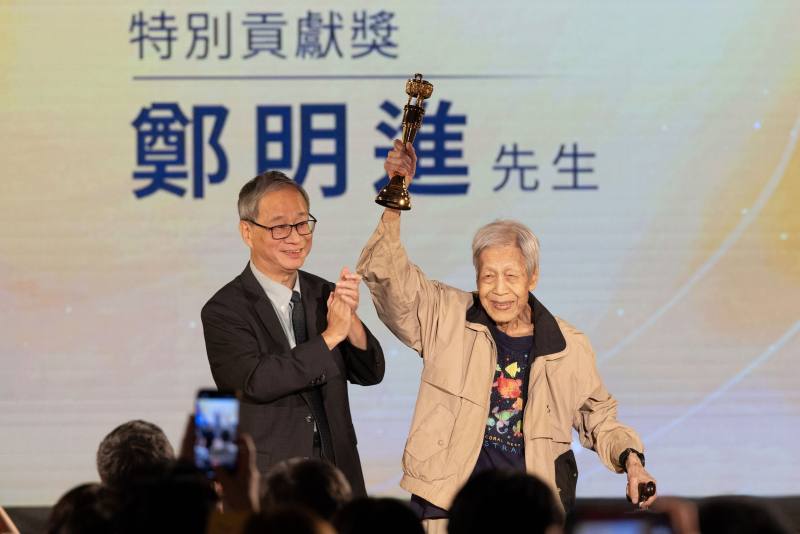 文化部長李遠（左）代表正在花蓮勘災的行政院長卓榮泰頒發特別貢獻獎予鄭明進（右），所有出版界後進給予最熱烈的掌聲及喝采