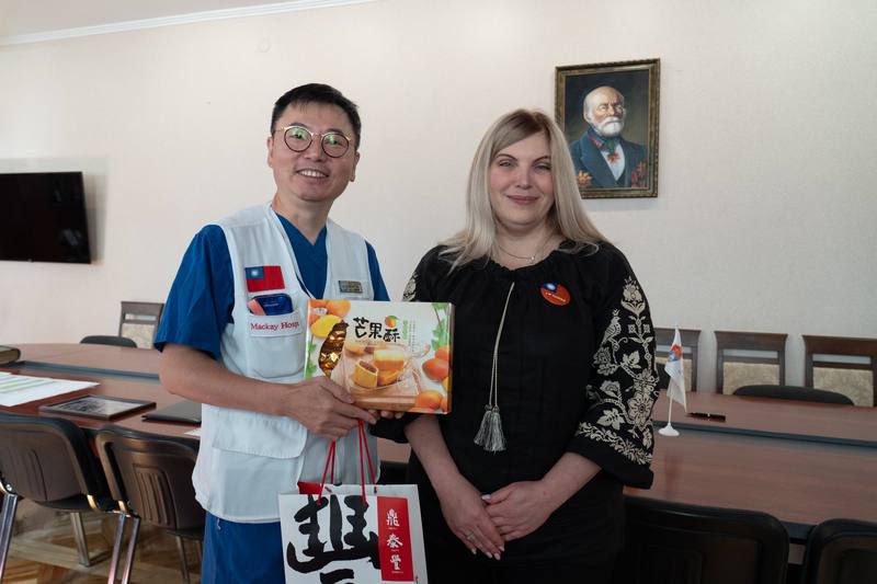 馬偕紀念醫院醫療團第6度前往烏克蘭執行義診與教育任務，期間與當地大學簽署合作備忘錄，未來將就臨床醫療與教育深化合作。圖為9月23日國際醫療中心主任蔡維德（左）贈送台灣鳳梨酥與芒果酥給大學醫學科院長彼特魯申科（右）。