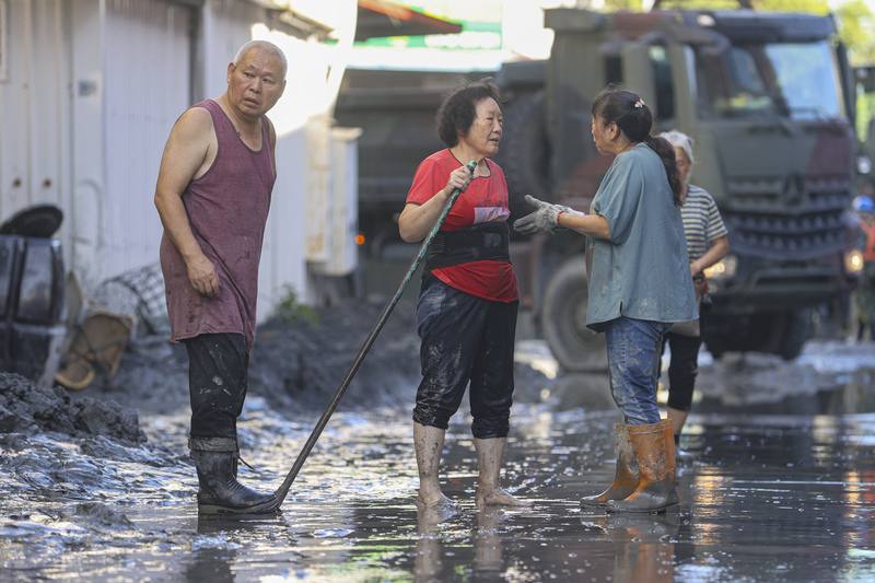 花蓮縣馬太鞍溪堰塞湖溢流致災，光復鄉街道25日布滿厚厚淤泥，災民們通力合作，一起重整家園。