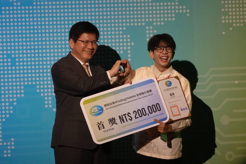 外交部長林佳龍（左）26日出席「尋找台灣 #FindingTAIWAN」全球徵片競賽頒獎典禮，頒發首獎給來自菲律賓的伊萬（Ivan Baleros）（右）