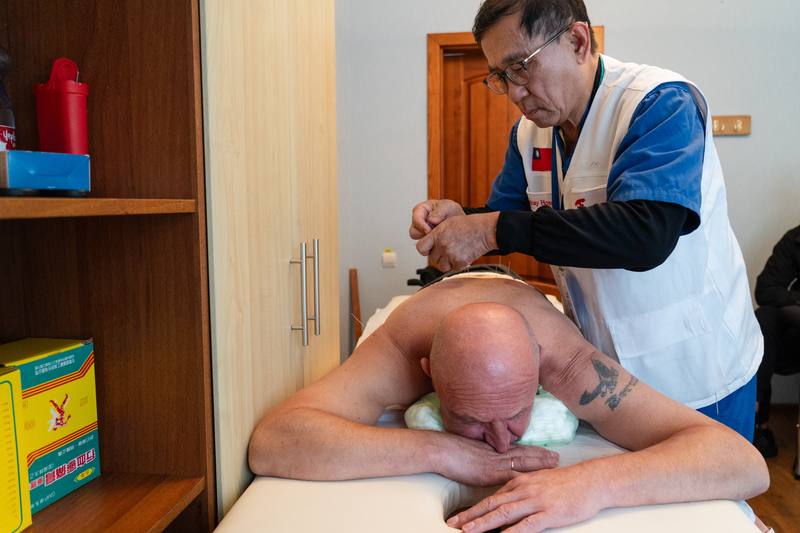 馬偕紀念醫院醫療團日前第六度前往烏克蘭進行義診與醫療教育交流，短短6天的義診內，團隊接待超過650人次。圖為9月24日中醫部主任陳光偉為下半身癱瘓的傷兵根納季進行針灸治療。