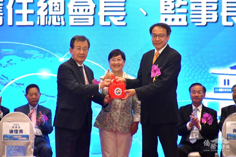 僑務委員會委員長徐佳青（中）監交世總第31屆總會長吳光宜（左）將印信交給世總第32屆總會長熊強生（右）