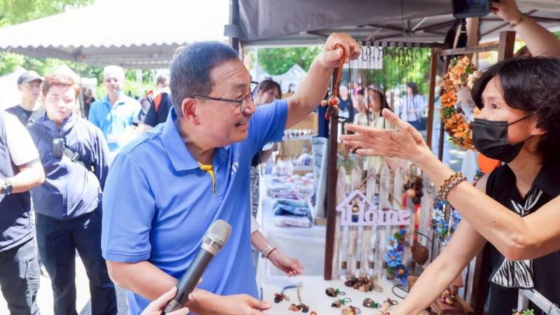 「2025新北市眷村文化節」27日在空軍三重一村熱鬧登場，新北市長侯友宜（前左）出席開幕式後也參觀現場市集攤位，與民眾親切互動。（新北市新聞局提供）